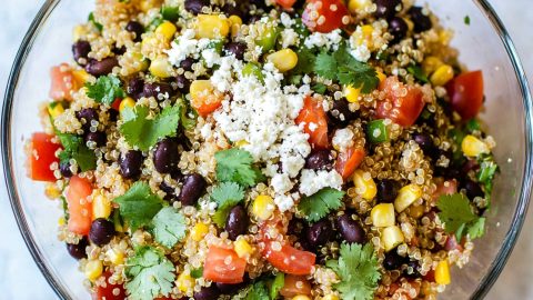 A vibrant Southwest quinoa salad featuring black beans, corn, diced tomatoes, and avocado, garnished with fresh cilantro.