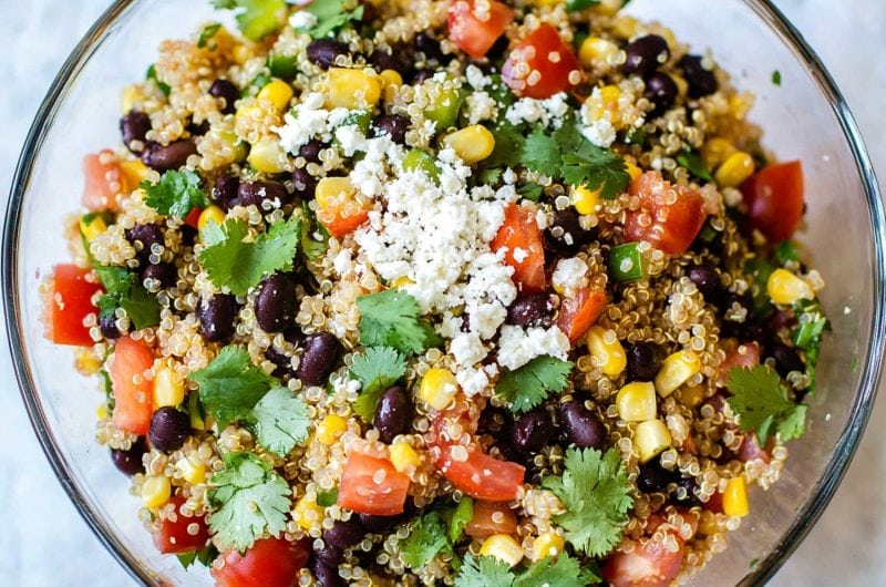 A vibrant Southwest quinoa salad featuring black beans, corn, diced tomatoes, and avocado, garnished with fresh cilantro.