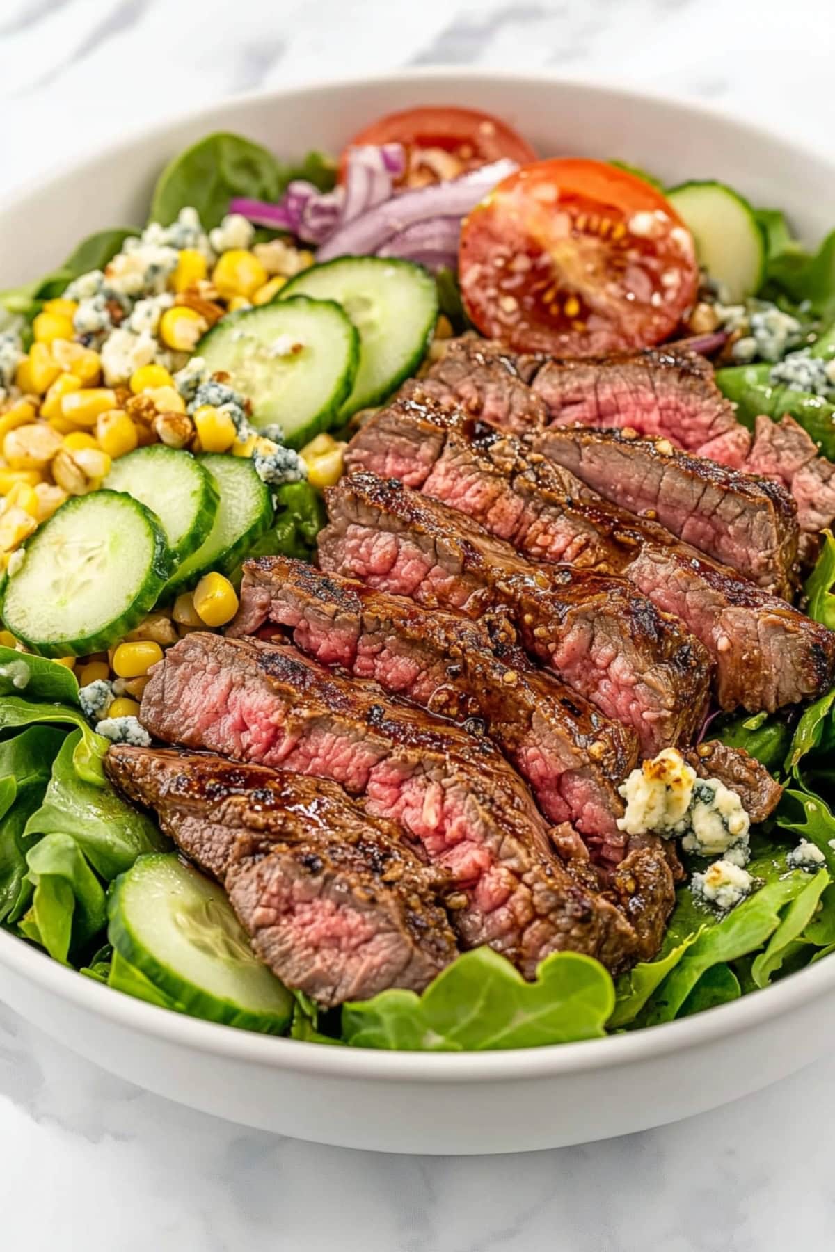 A hearty steak salad with tender steak slices, veggies, crumbled blue cheese and dijon mustard dressing
