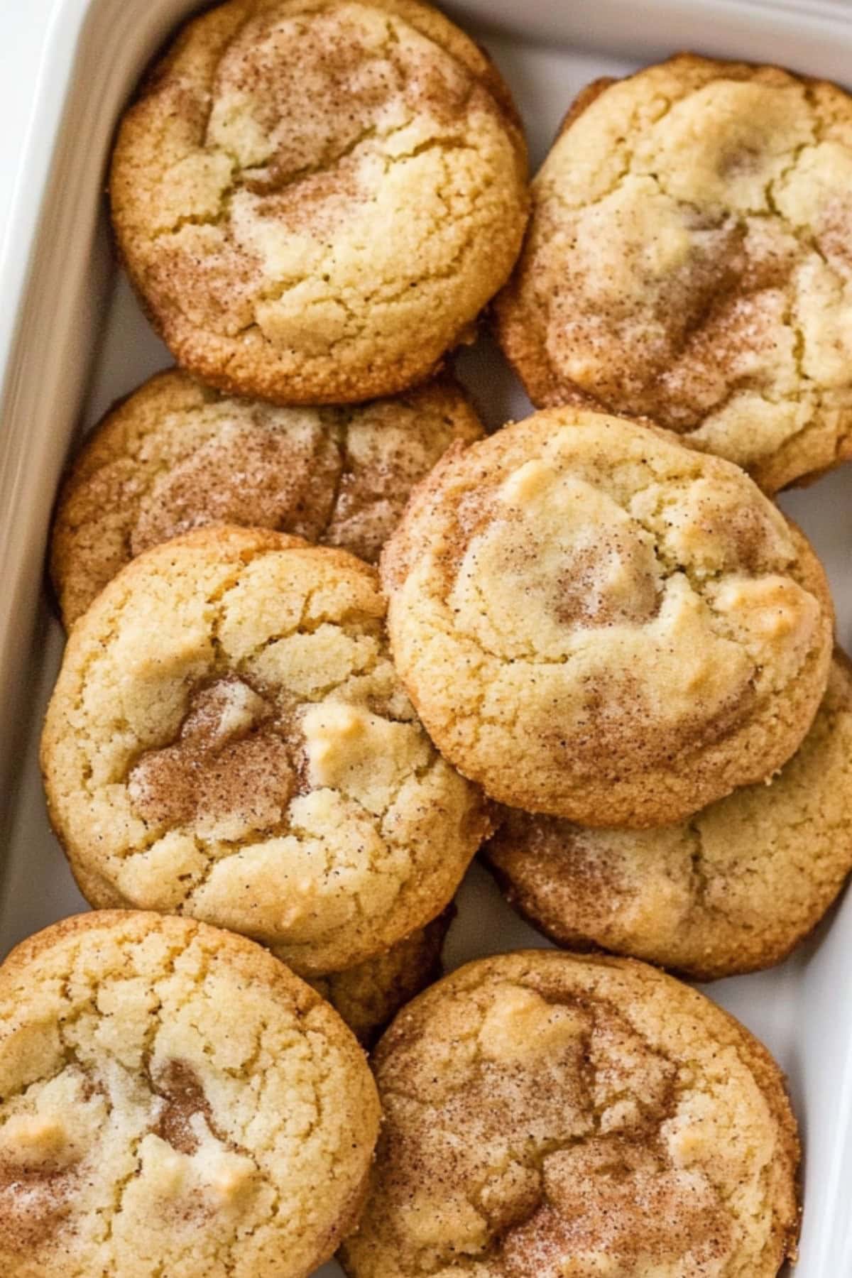 A baking sheet of toffee doodle cookies with cinnamon sugar coating, top view.