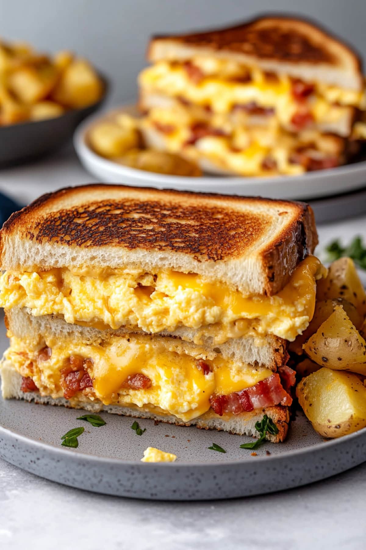 Breakfast grilled cheese with scrambled eggs and bacon served on a plate with homefries