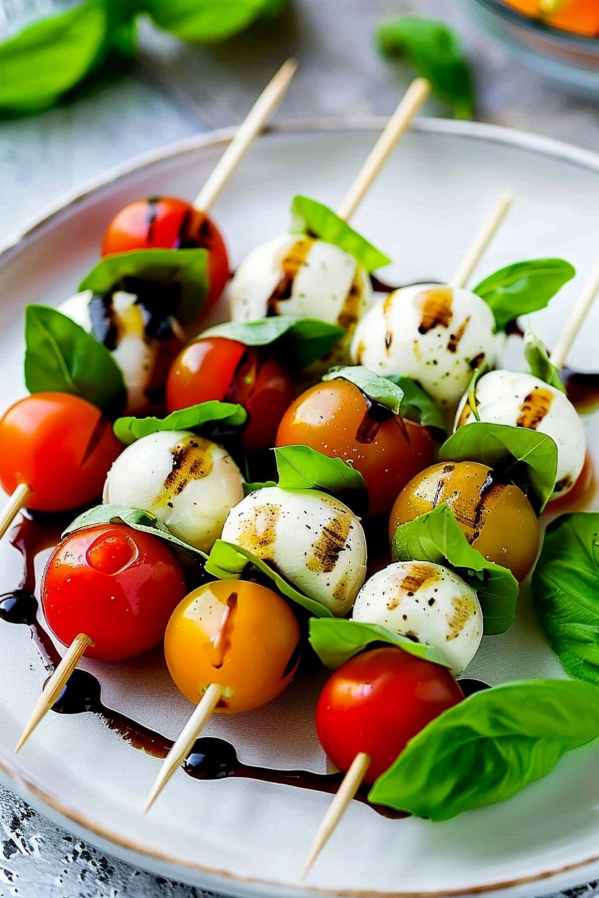 Skewered cherry tomato, mozzarella balls and basil, drizzled with balsamic glaze.