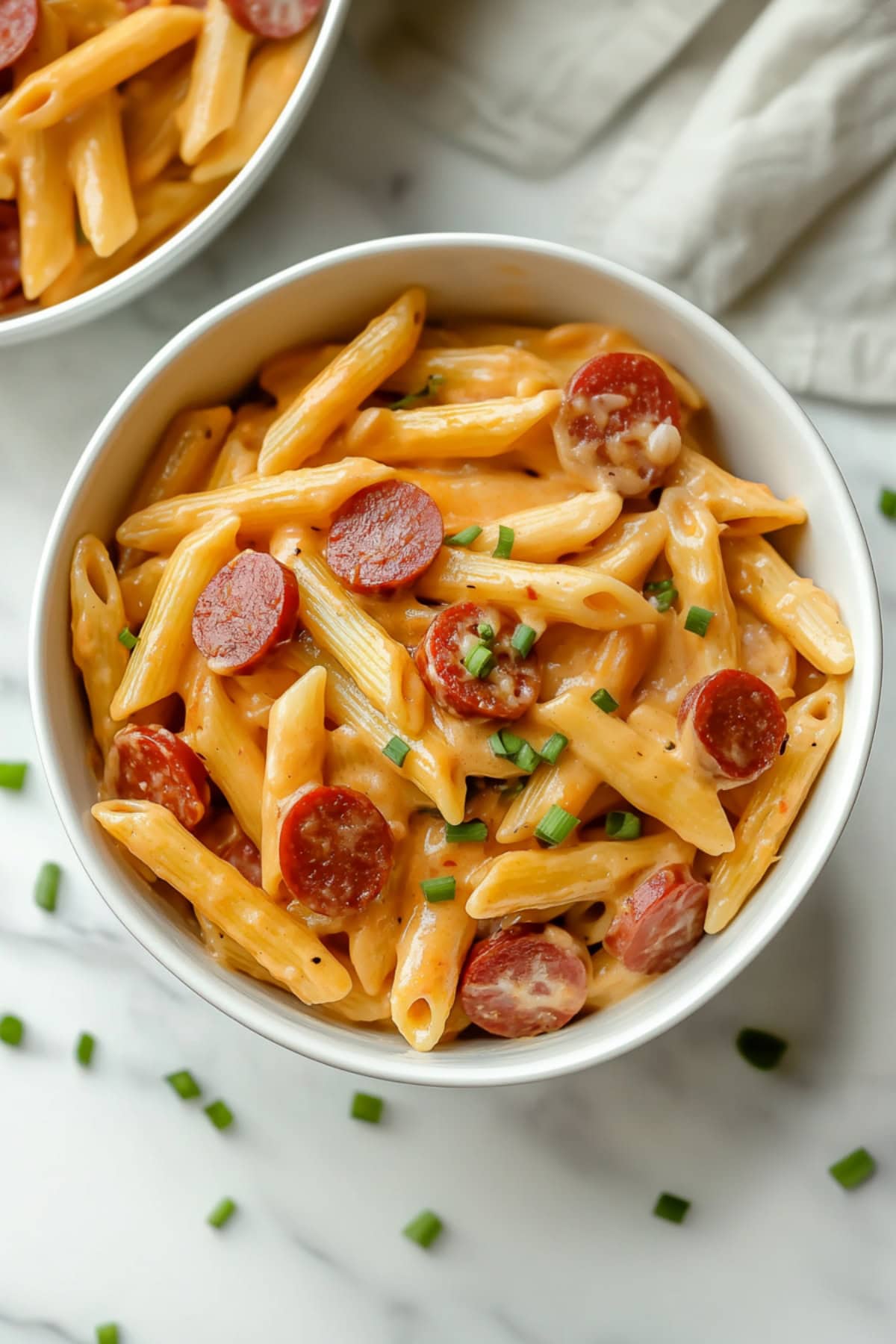 Homemade cheesy kielbasa pasta topped with diced onions.