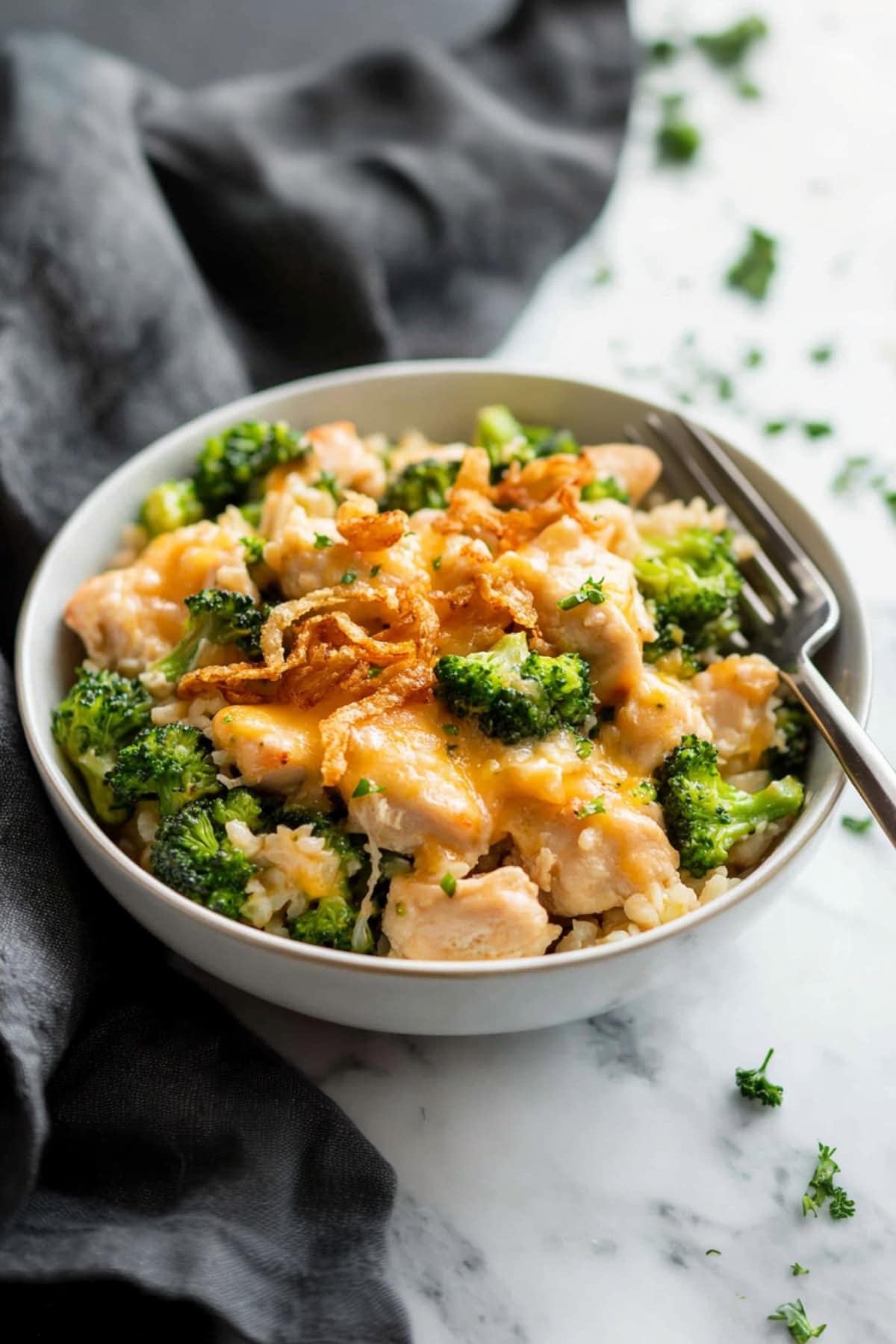 A bowl of chicken broccoli rice casserole with fried onions.