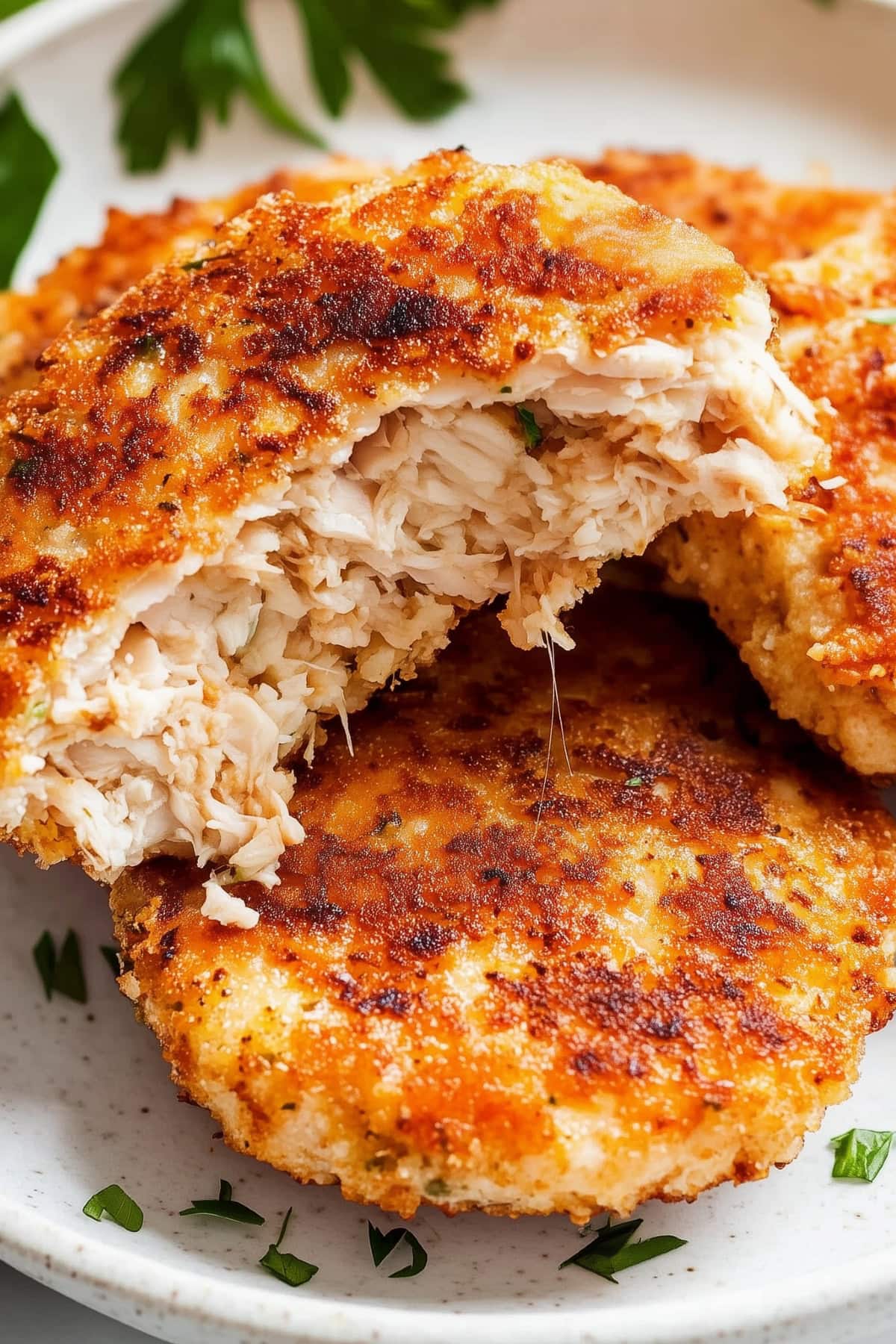 Close-up of crispy, golden-brown chicken patties in a plate.