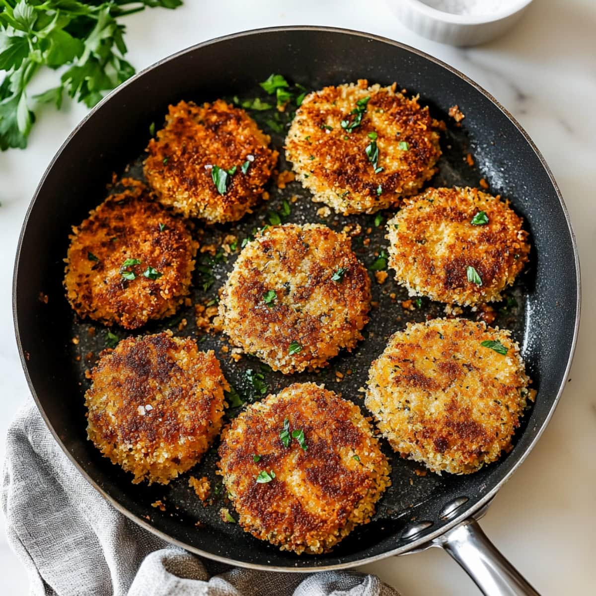 A skillet filled with homemade crispy chicken patties.