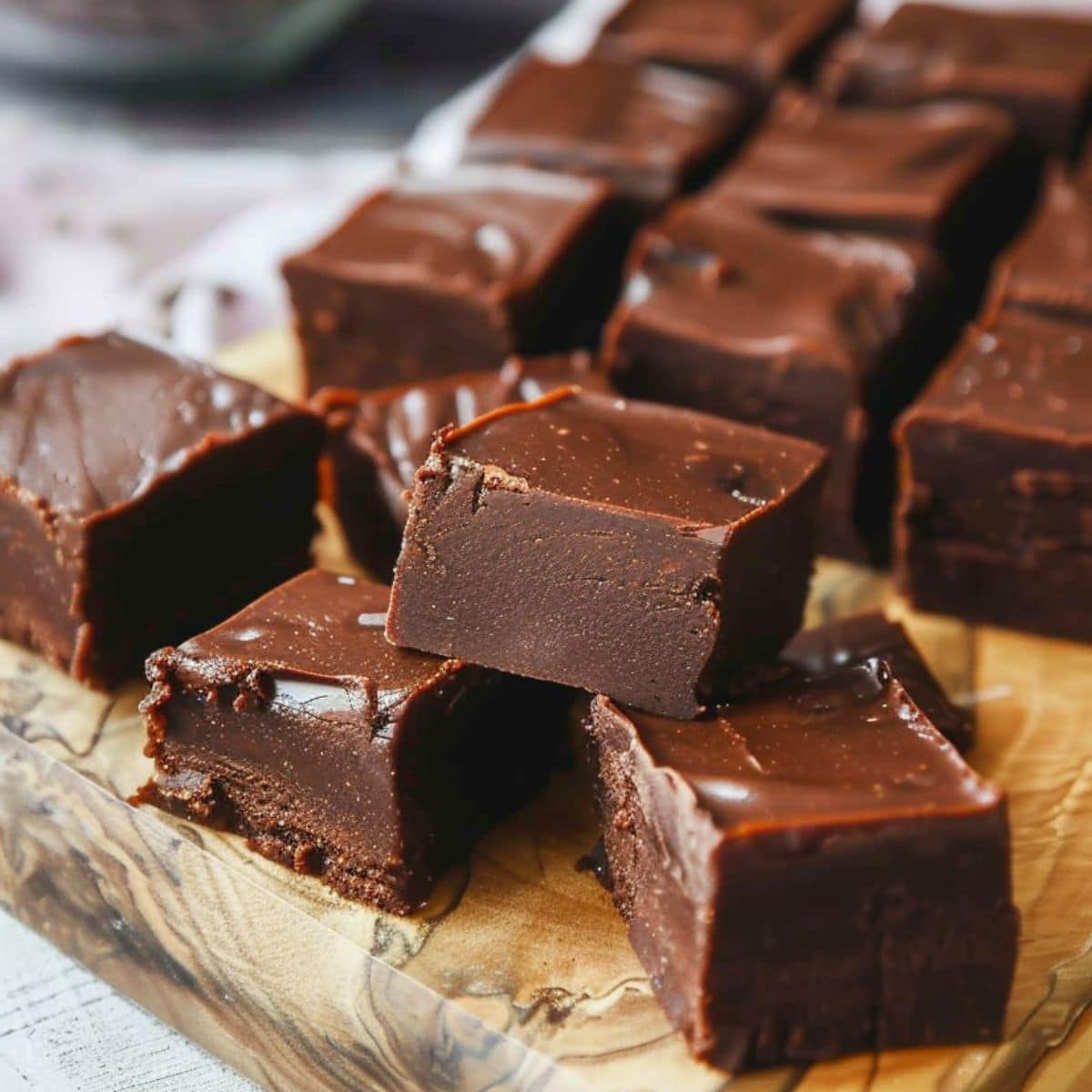 Rich and creamy 3-ingredient chocolate fudge on a wooden board.