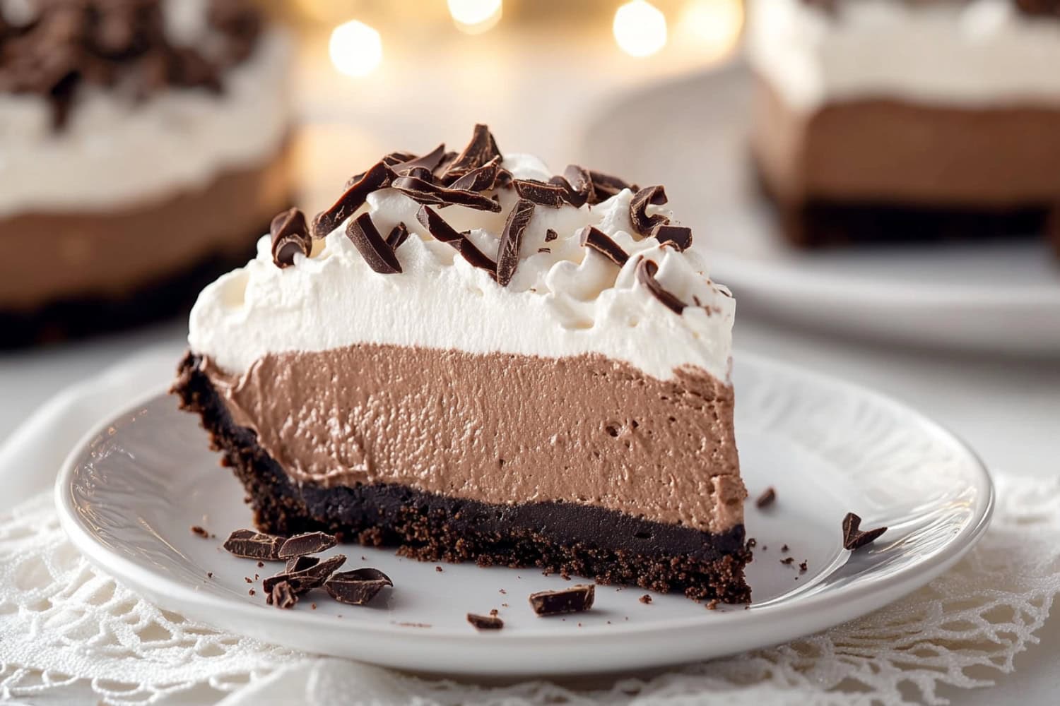 Glossy chocolate mousse pie with whipped cream in a plate.