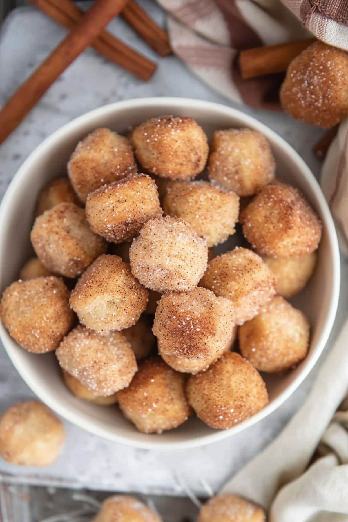 Top view of a bowl filled with cinnamon sugar coated biscuit bites.