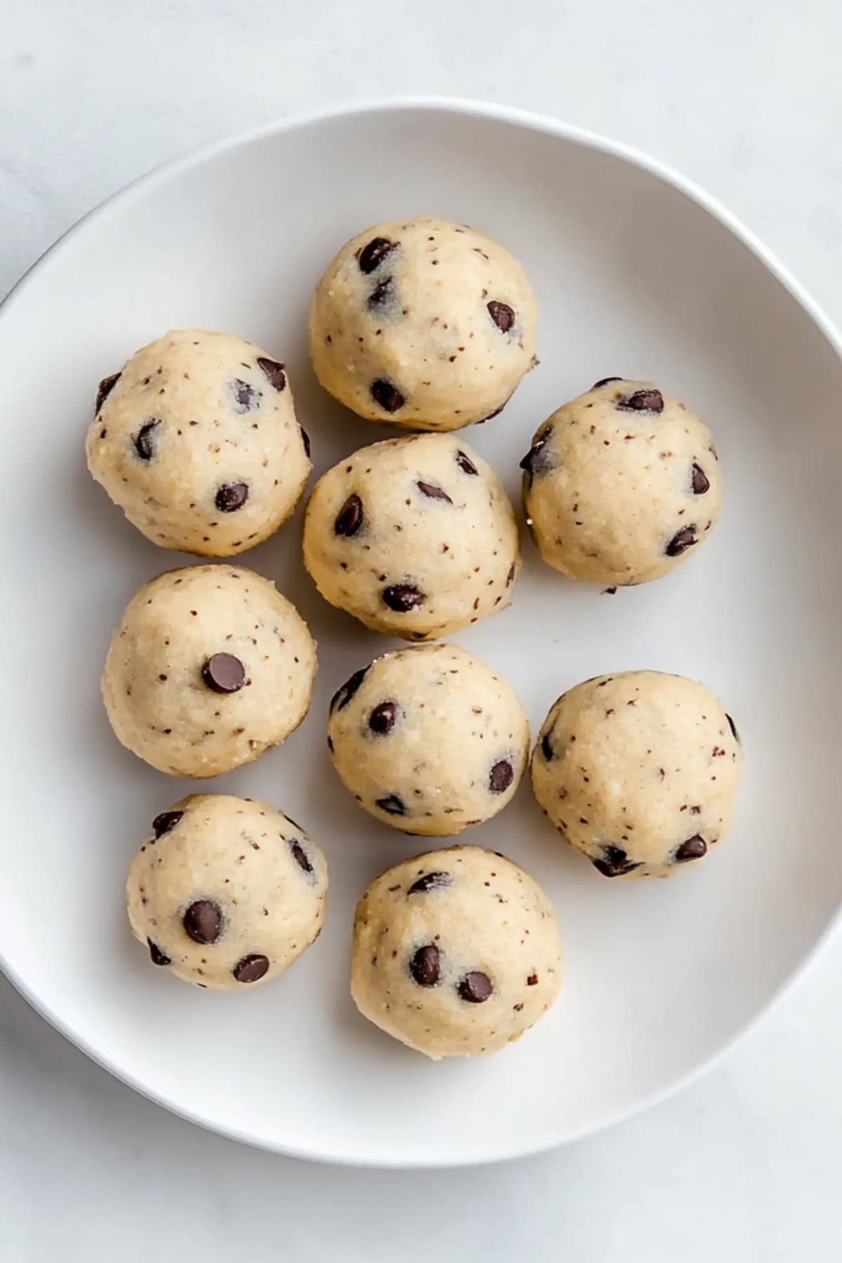 A plate of cookie dough balls, top view.