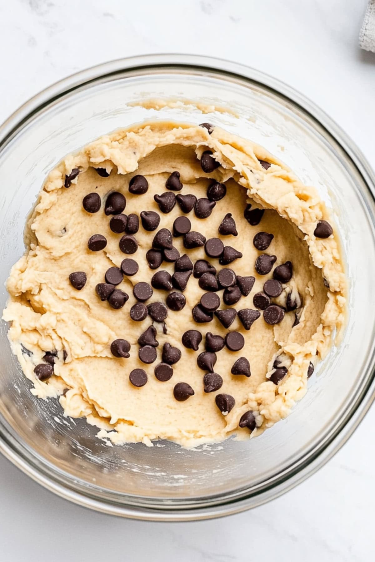 A glass bowl of chocolate chip cookie dough.