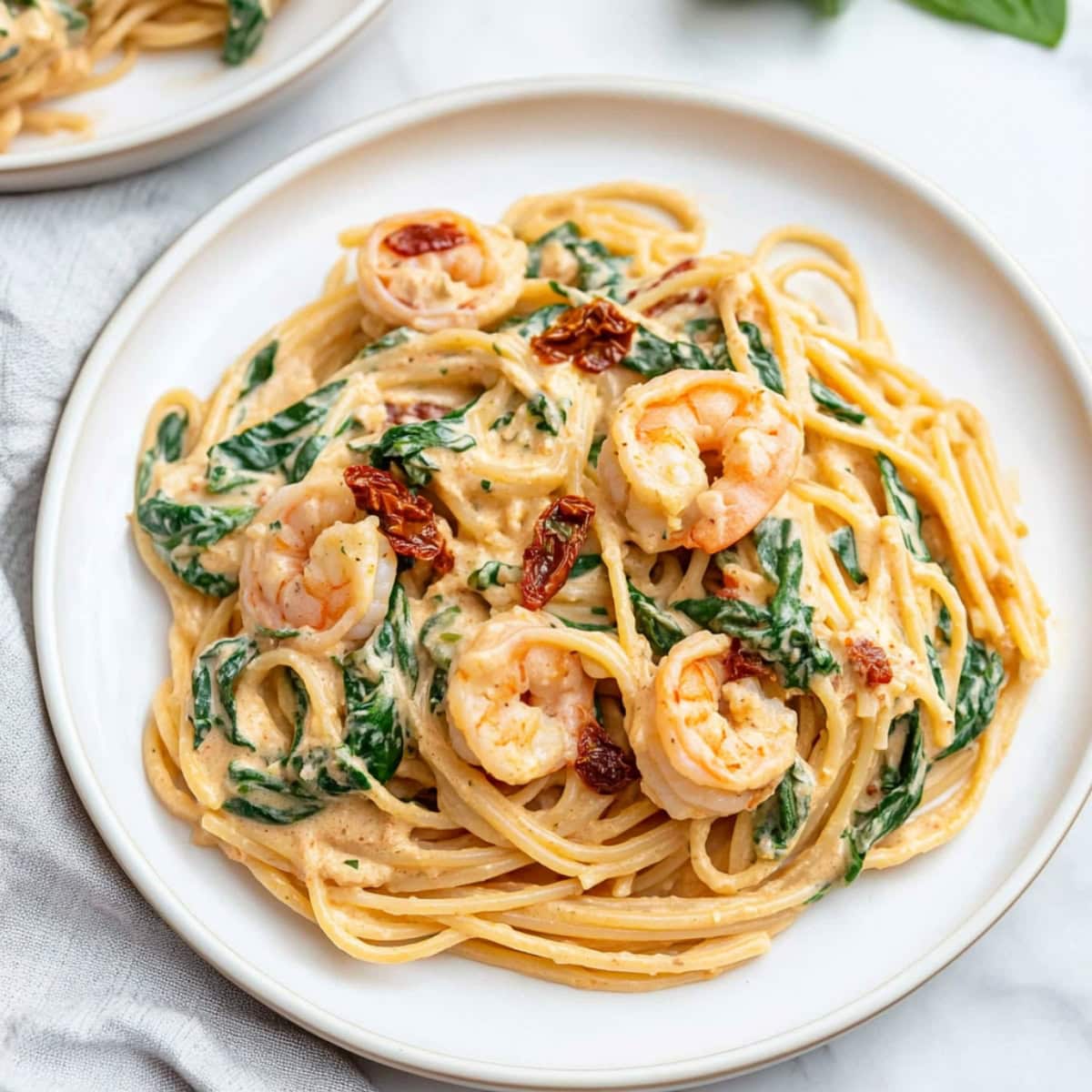 Spaghetti in a creamy sauce with shrimp, sun-dried tomatoes and spinach.