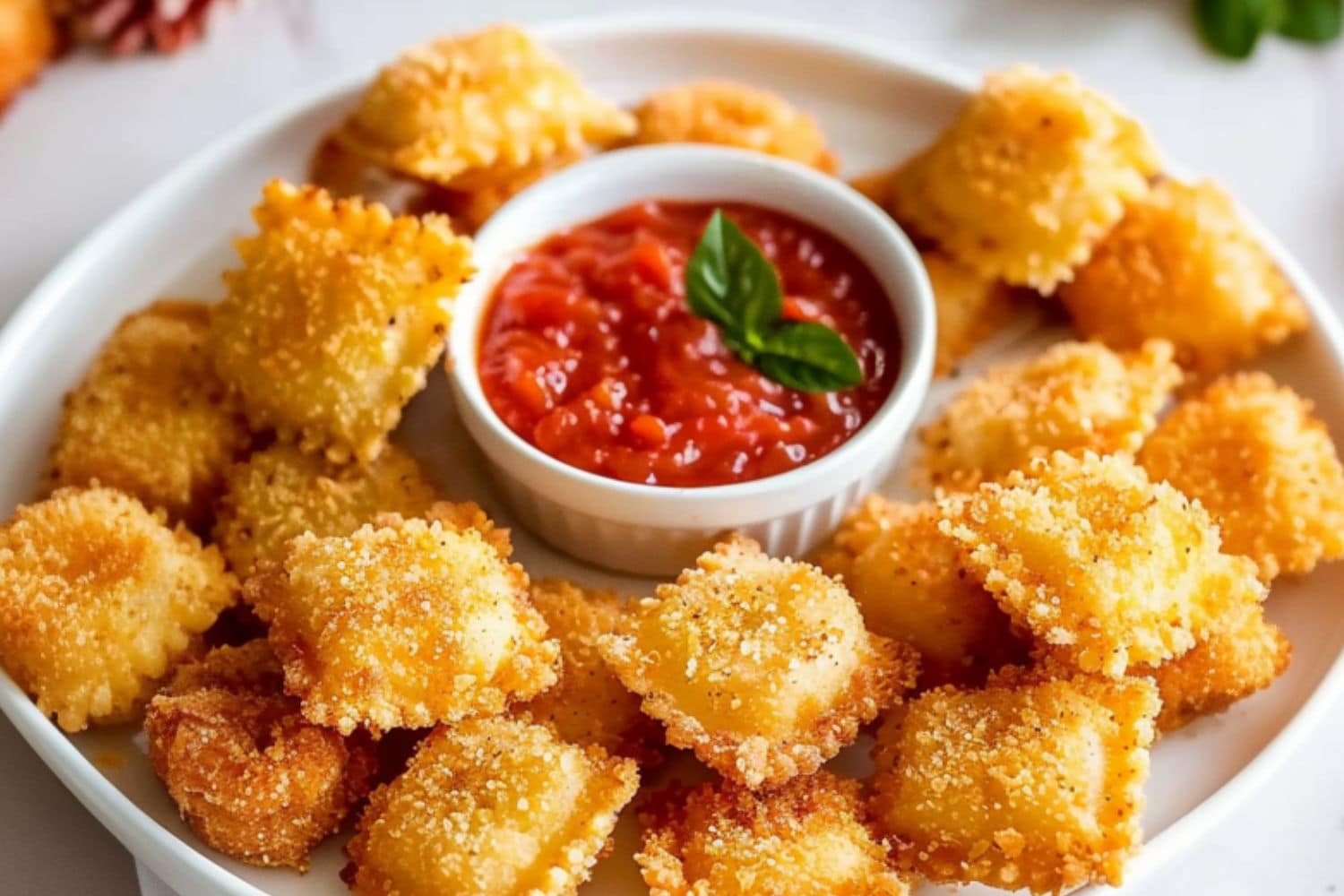 Platter of crispy fried ravioli served with marinara sauce.