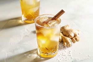 Gingerbread fizz in sugar rimmed glasses served with ice and cinnamon stick.