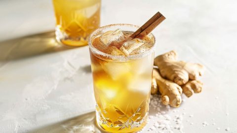 Gingerbread fizz in sugar rimmed glasses served with ice and cinnamon stick.