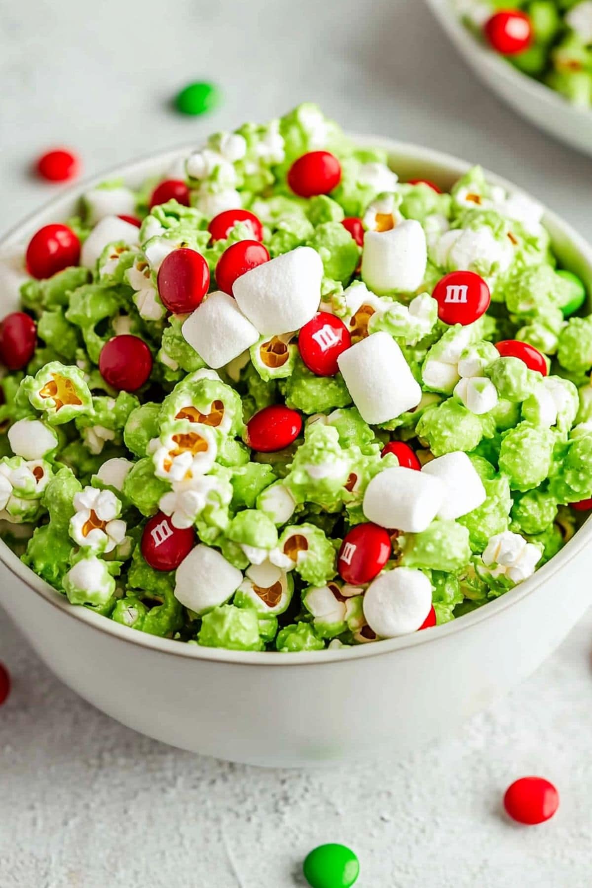 Bowl full of Grinch popcorn with mini marshmallows and red M&M candies 