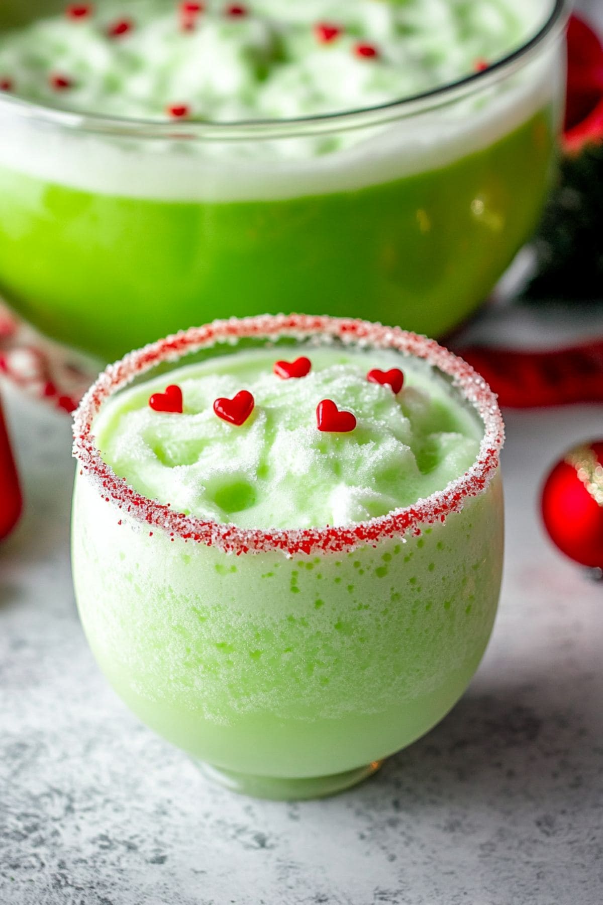 Green punch with frothy toppings garnished with candy sprinkles.