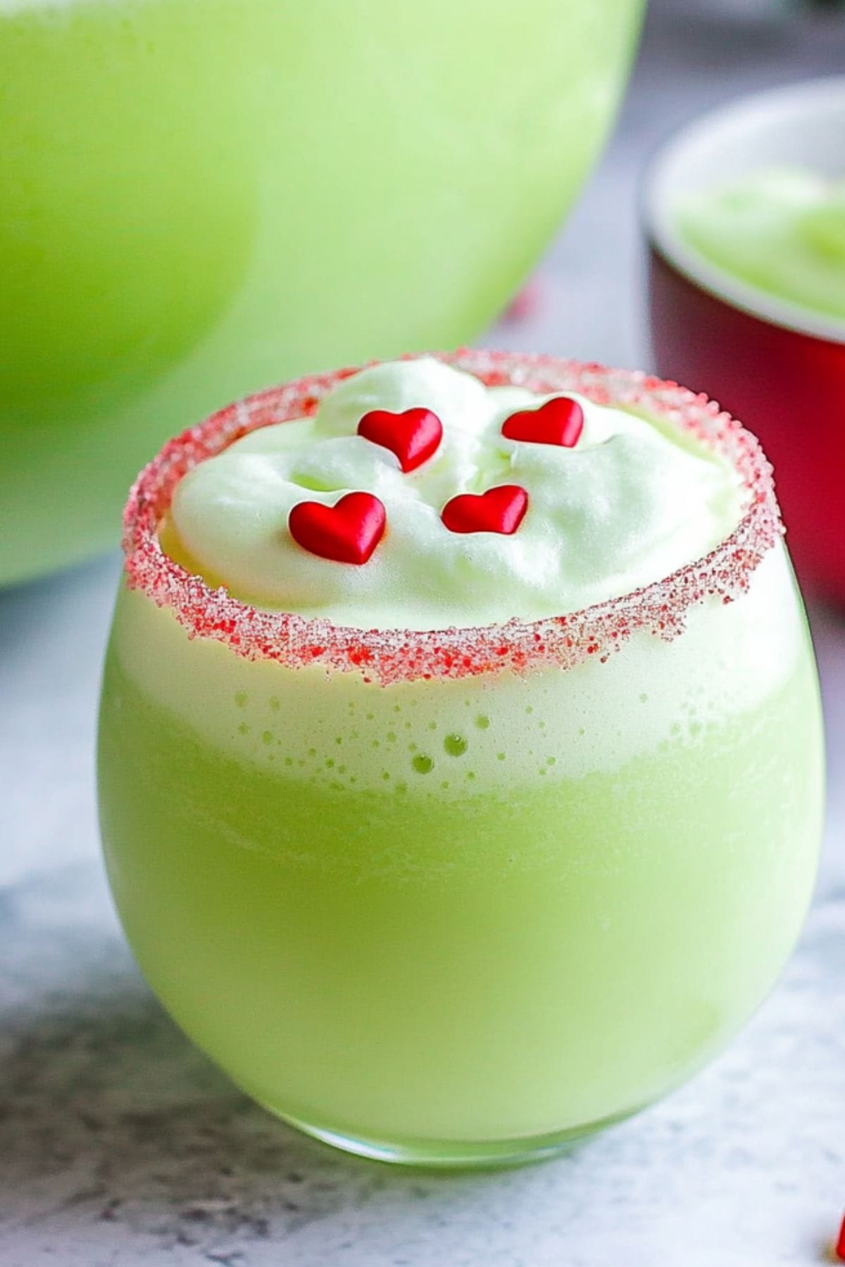 Grinch punch serving in a red sugar rimmed glass.