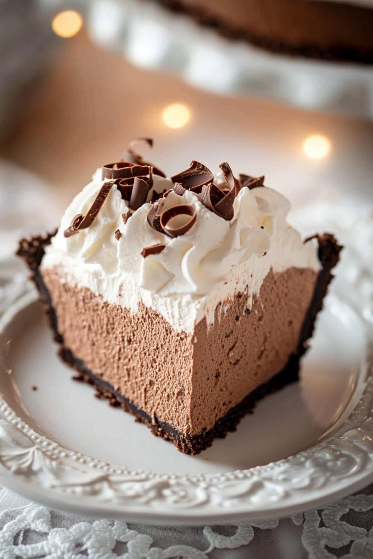 A close-up of creamy chocolate mousse and whipped cream pie with chocolate shavings.