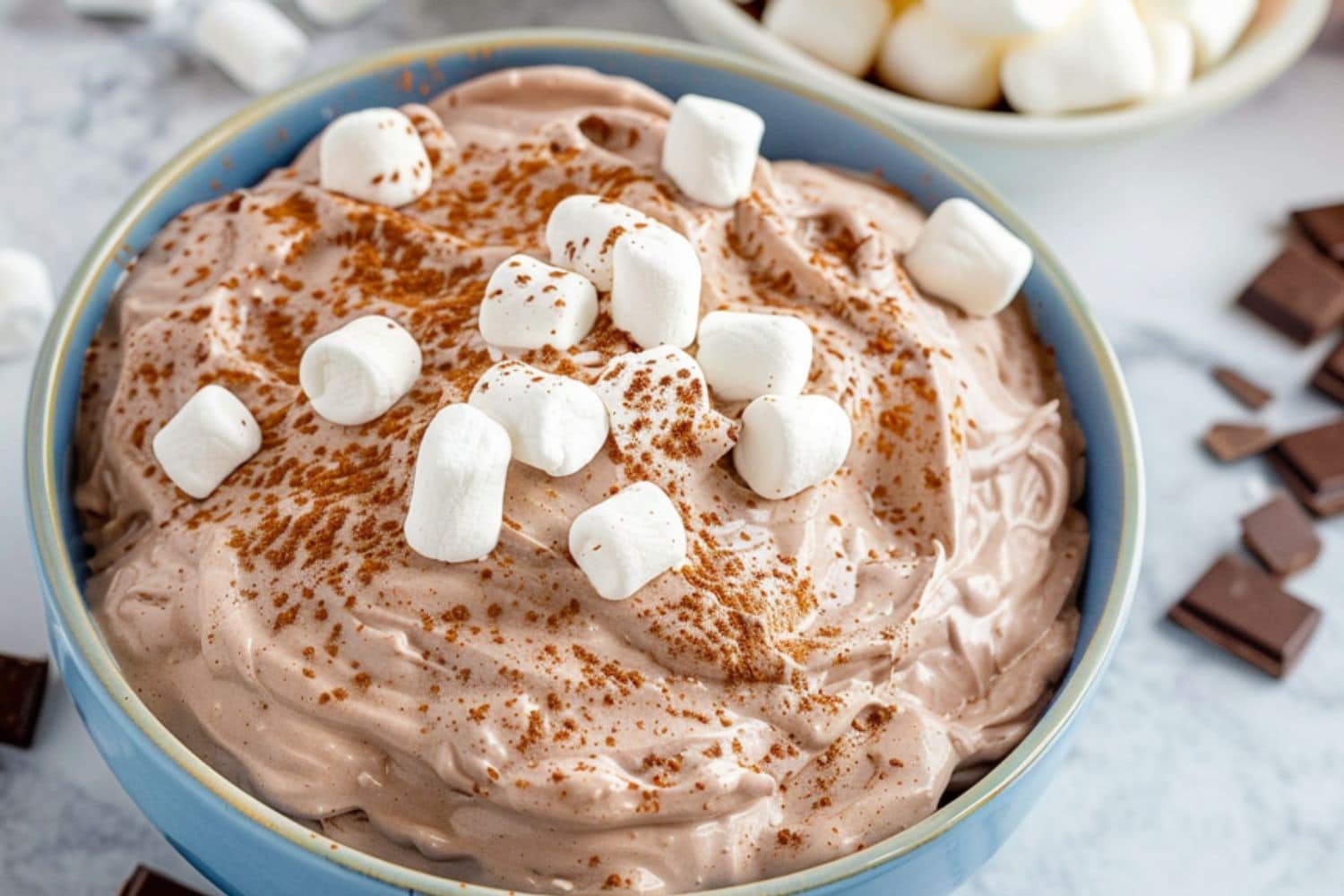 Fluffy and creamy chocolate dip with marshmallows served in a blue bowl.