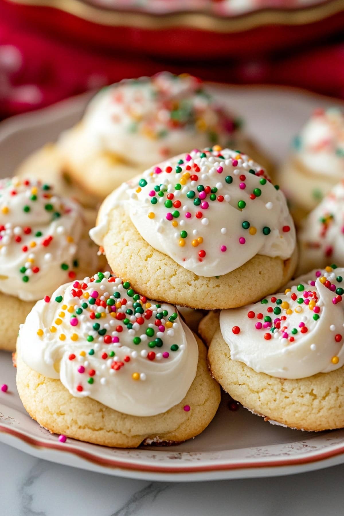 A plate of Italian ricotta cookies with sweet glaze and colorful candies in a plate.