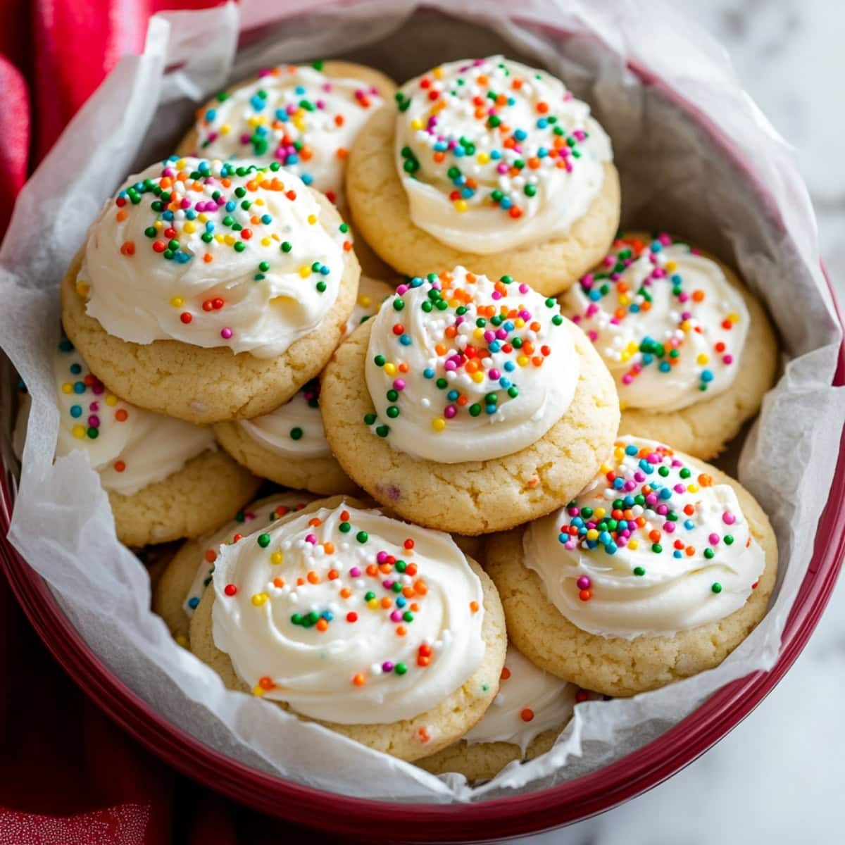 An overhead view of Italian ricotta cookies with sprinkled candies and sweet glaze.