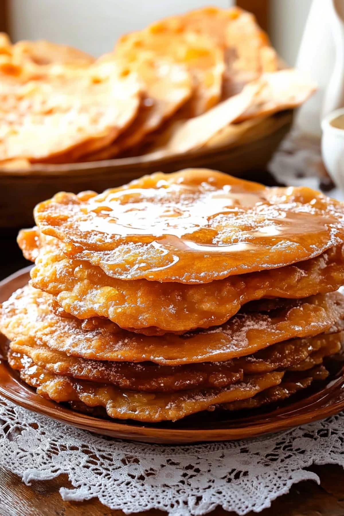 Mexican bunuelos with syrup in a wooden plate.