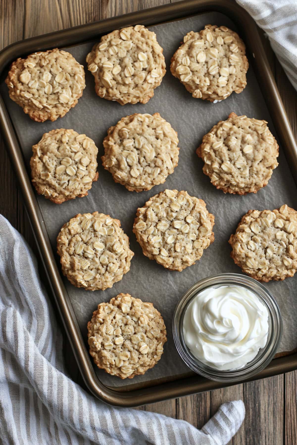 Oatmeal Cookies on a Baking Tray with Frosting on the Side