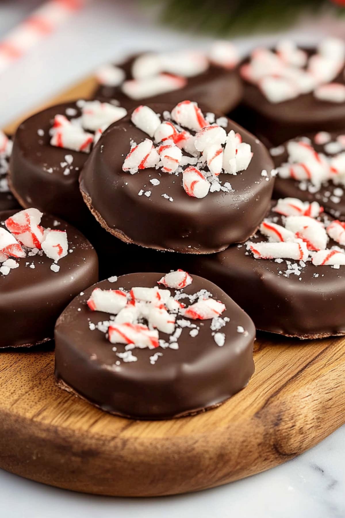 A wooden board of peppermint patties topped with crushed candies.