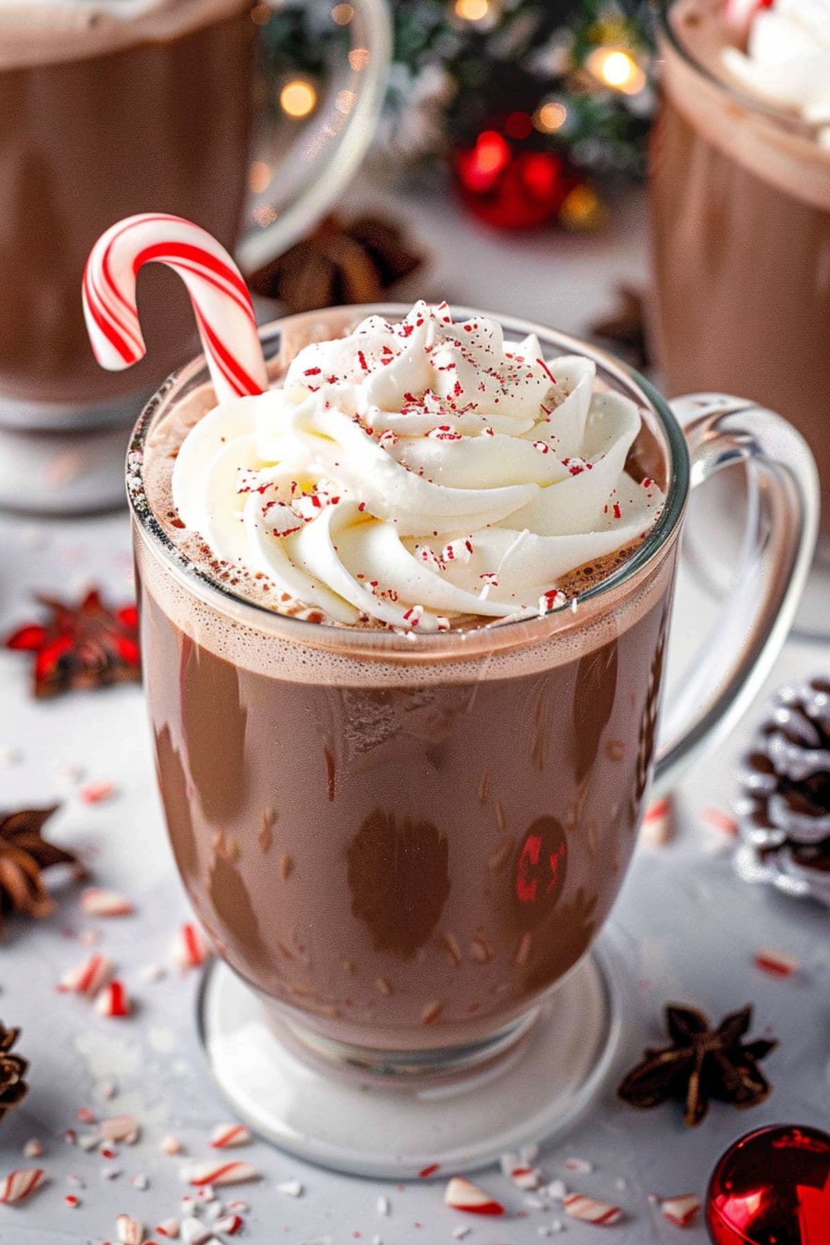 Creamy and chocolatery drink served in glass mug with whipped cream and crushed peppermint.