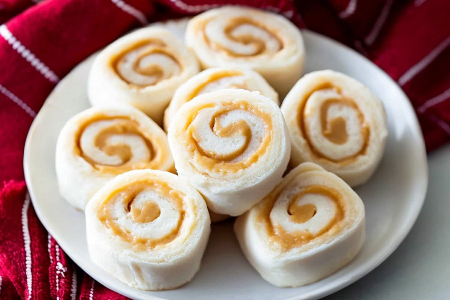 A plate of potato candy with peanut butter filling on a white marble table