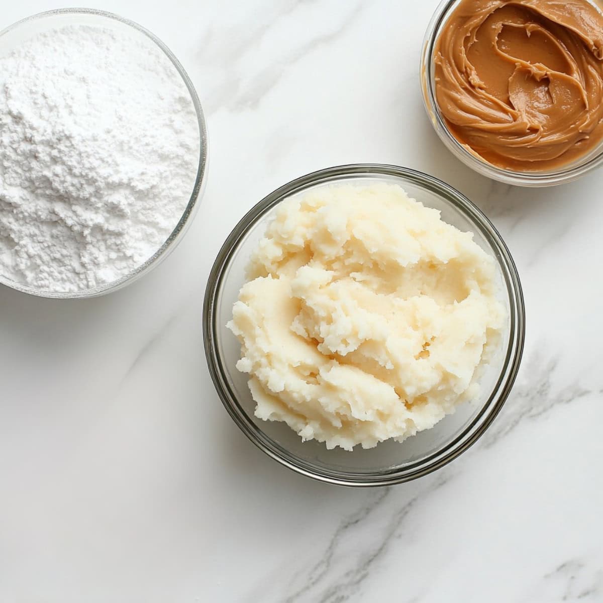 Potato Candy Ingredients - Mashed Potatoes, peanut butter and powdered sugar in glass bowls.