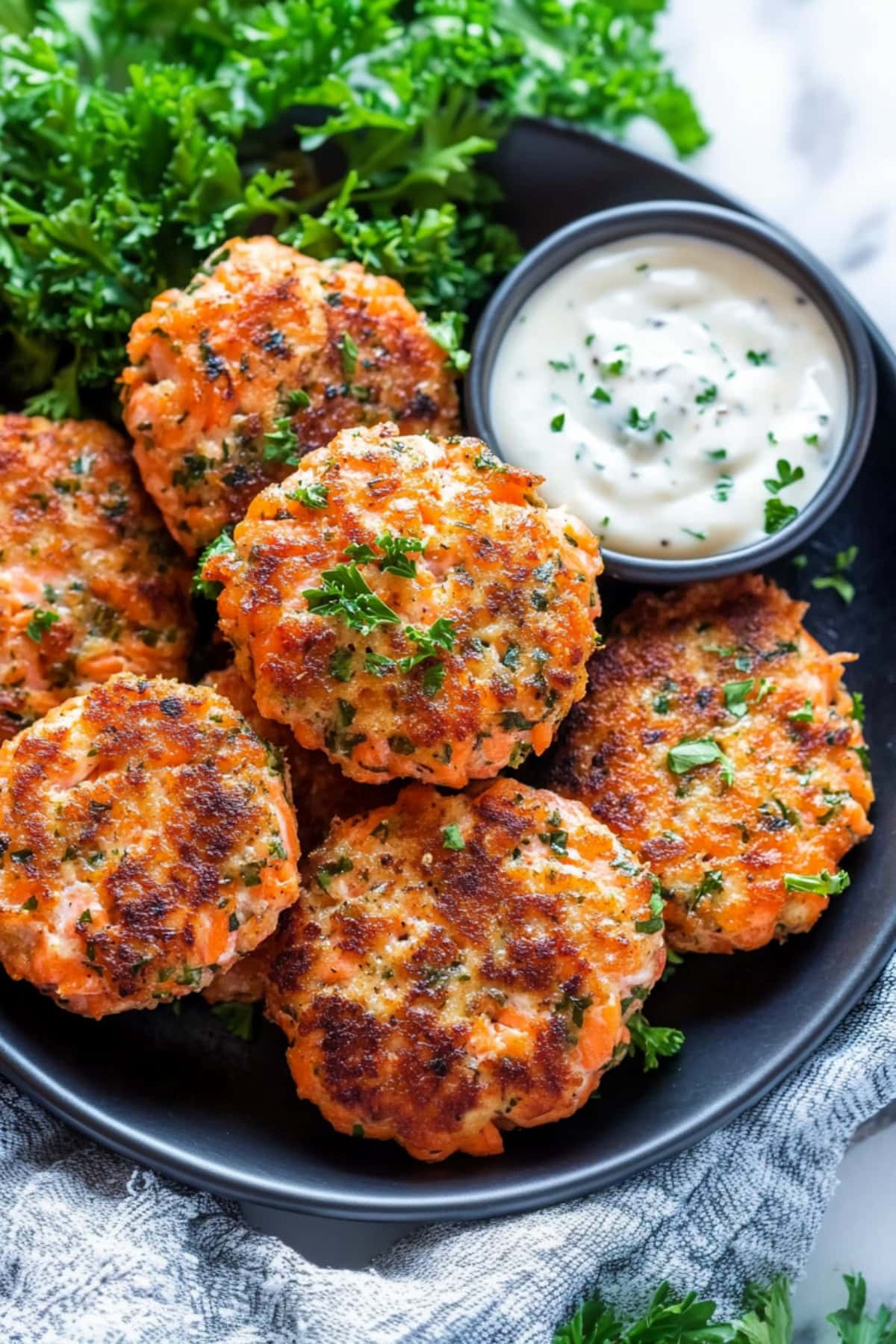 Salmon cakes served with aioli dip in a plate.