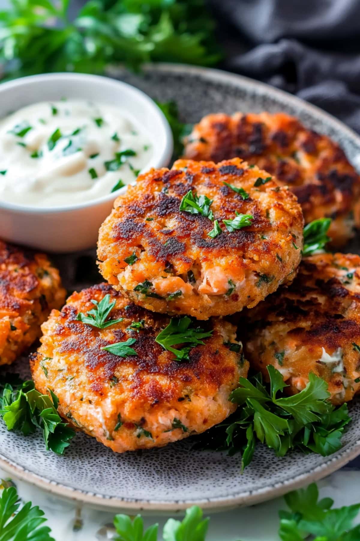 A plate of golden-brown salmon cakes, crispy on the outside and flaky on the inside.