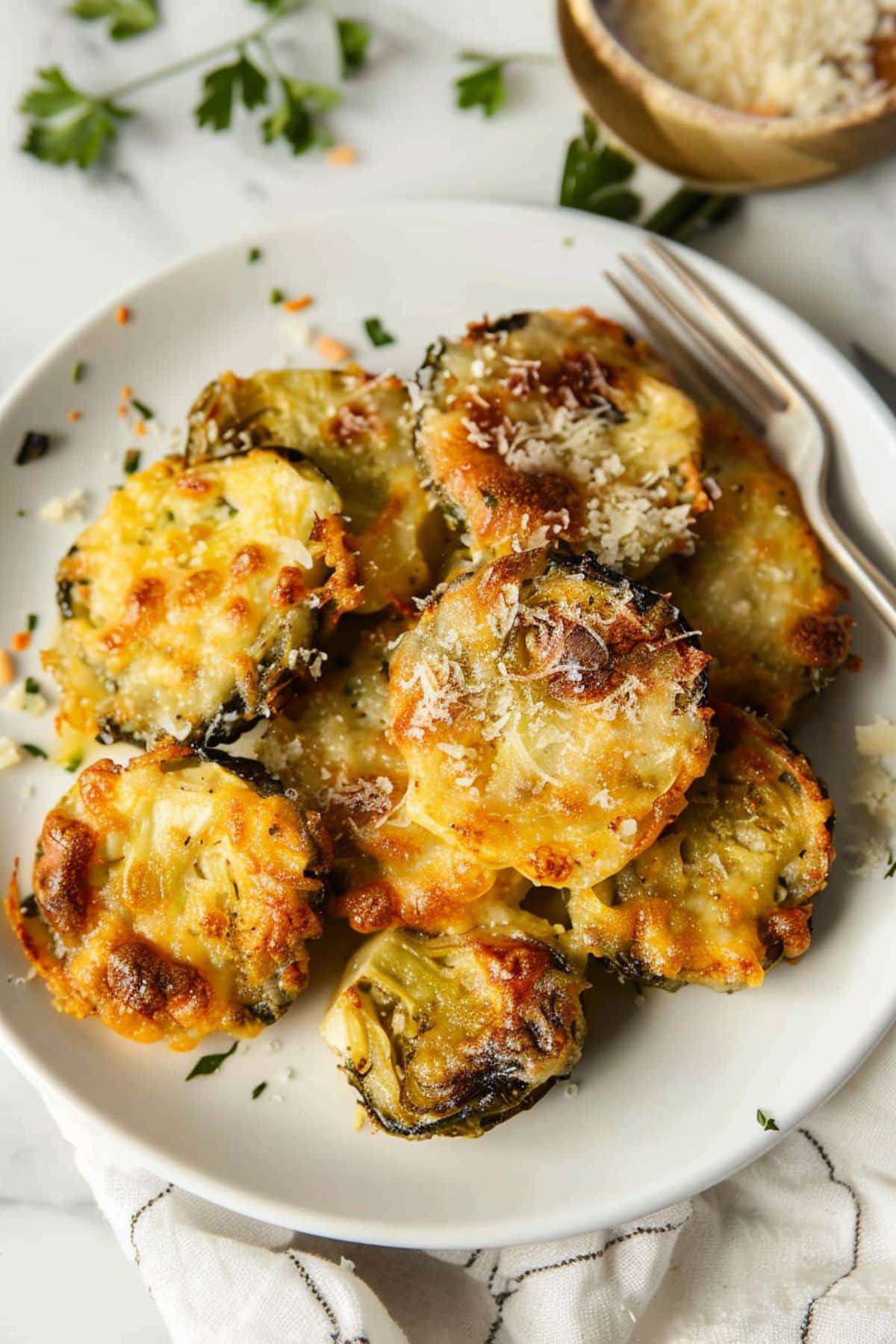 Baked cheesy smashed Brussels sprouts placed on a white plate.