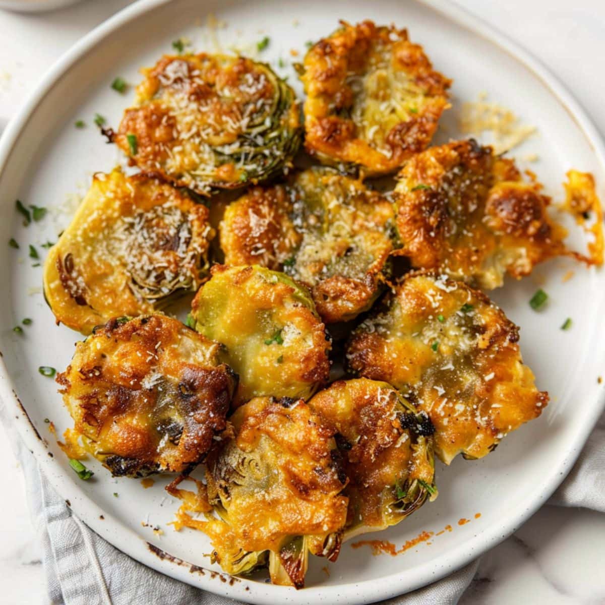 Cheesy baked smashed Brussels sprouts served on a plate, top view