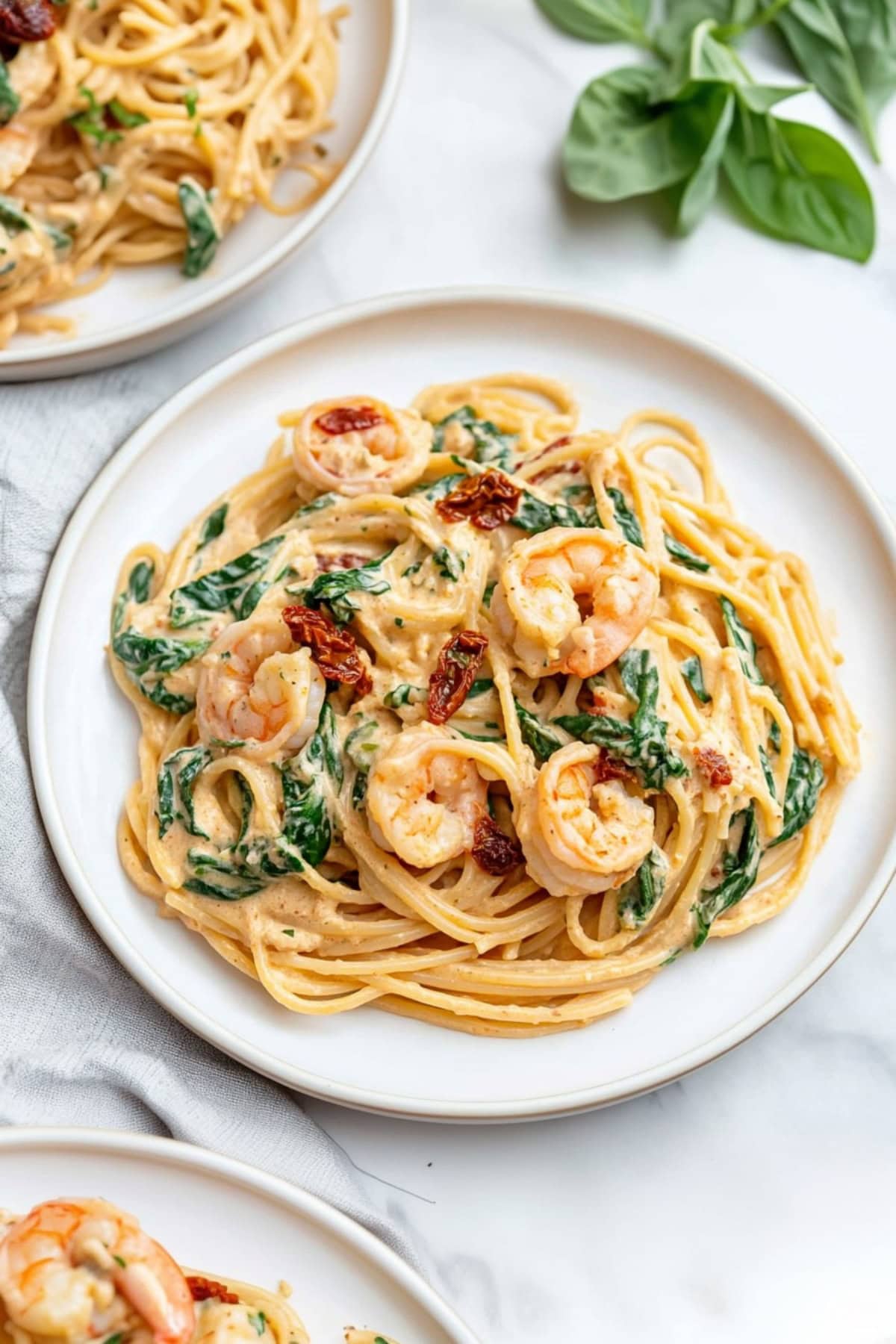 A vibrant dish of Tuscan shrimp pasta with spinach and sun-dried tomatoes.