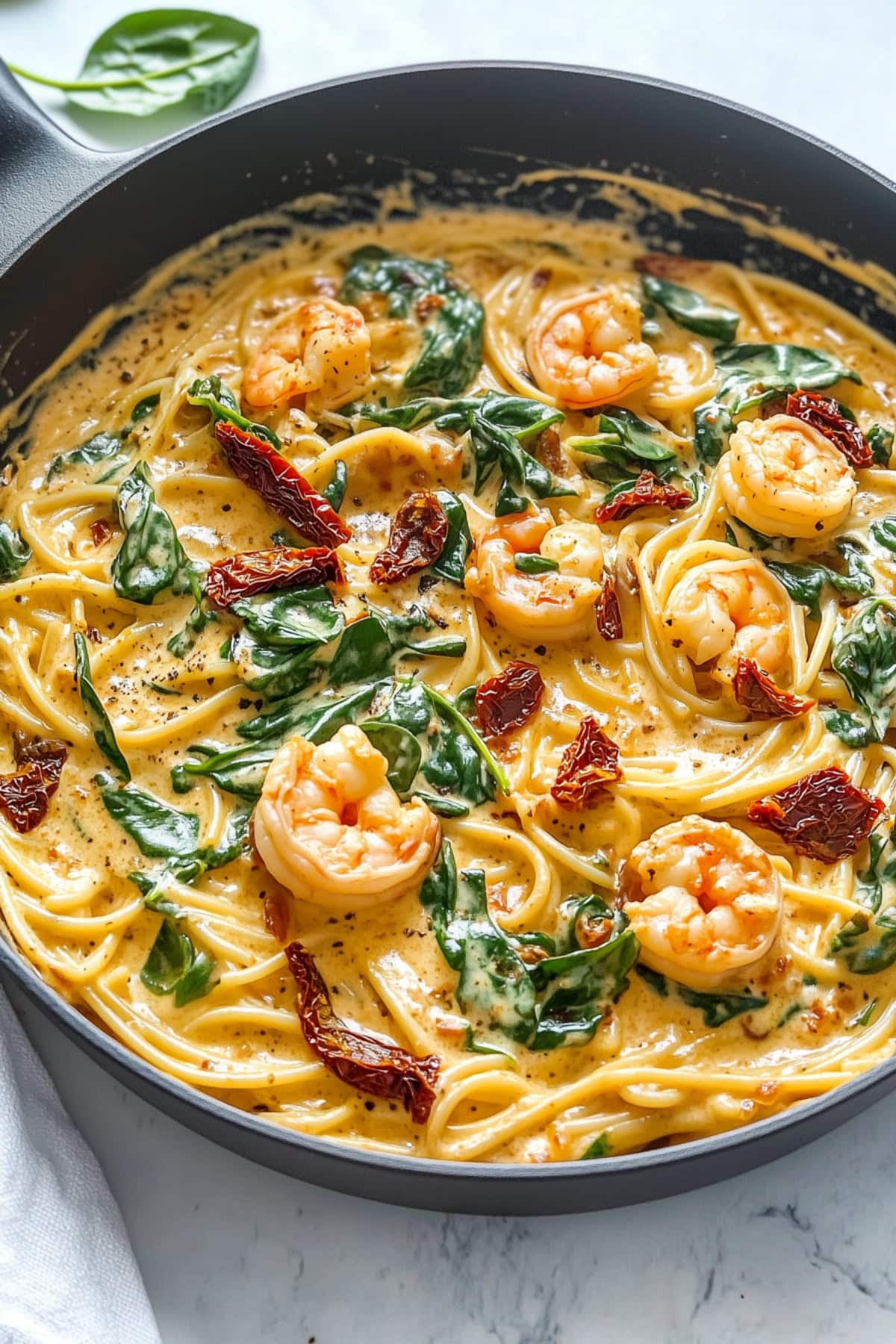 Creamy homemade tuscan shrimp pasta with spinach and sun-dried tomatoes.