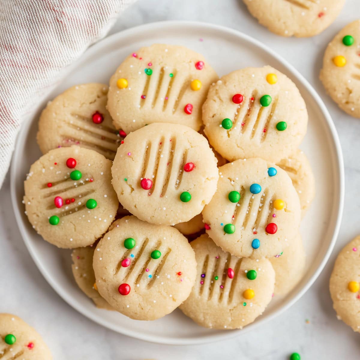 An overhead of whipped shortbread cookies with colorful candies.