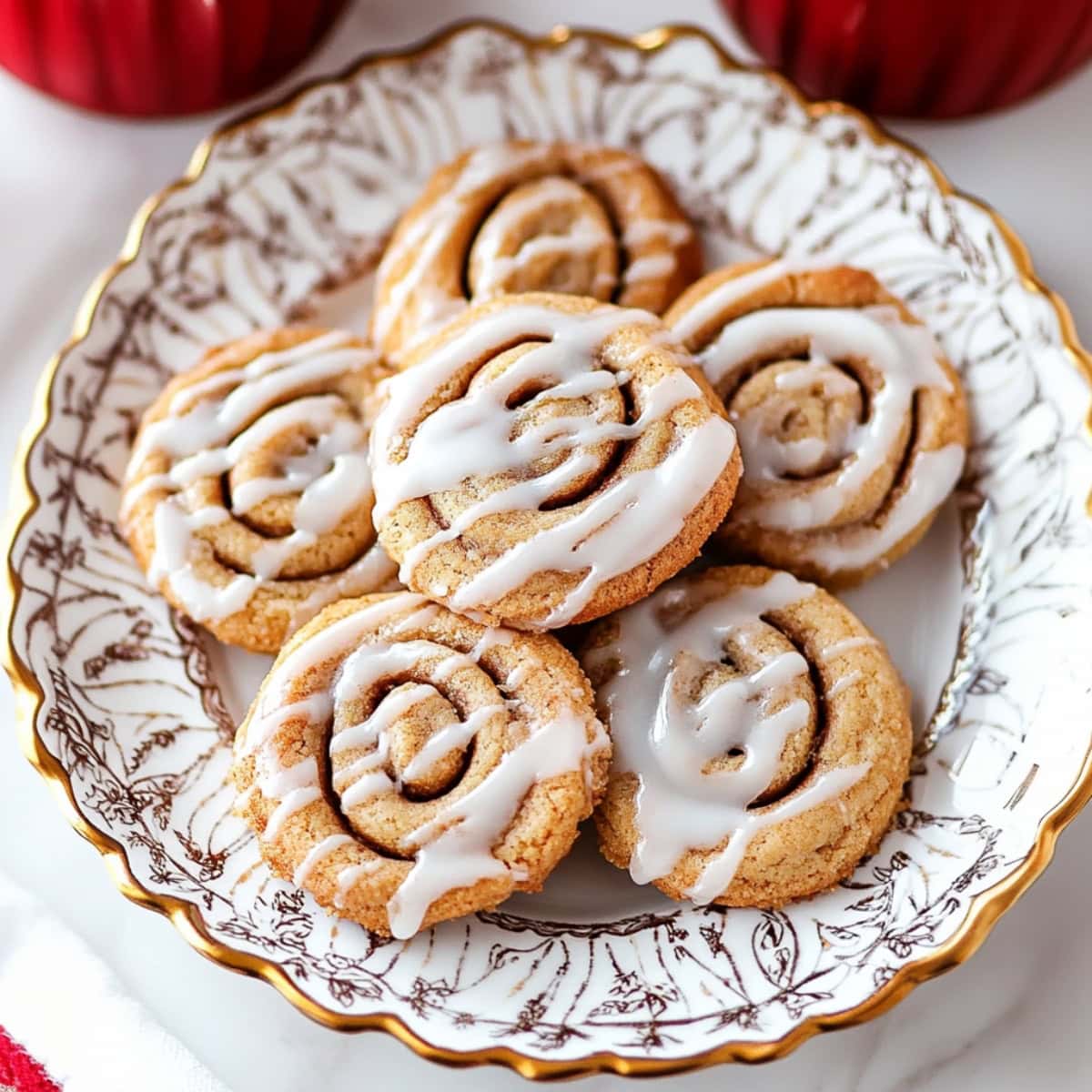 Cinnamon roll cookies with sweet cream cheese glaze on a decorative plate, top view