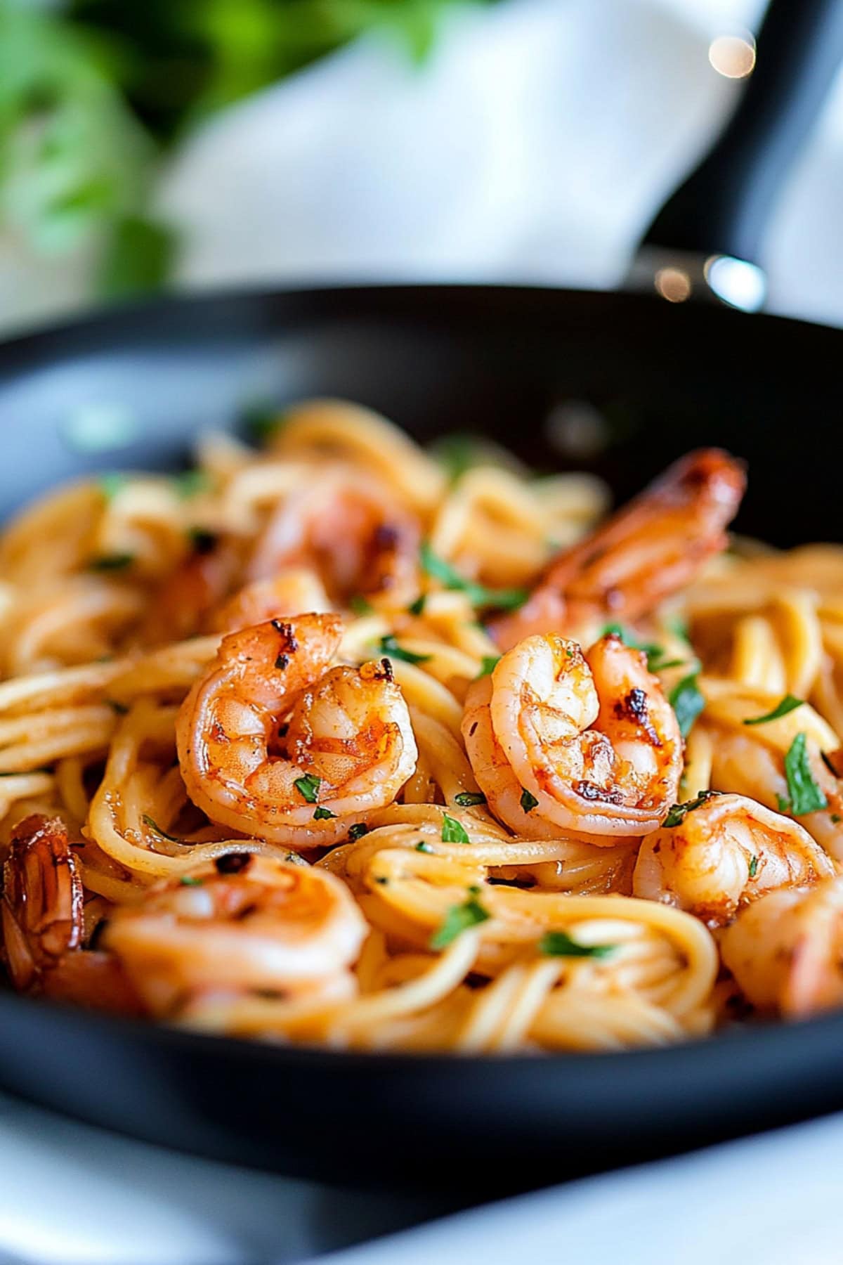 Pasta cooked with creamy sauce and shrimp in a pan.