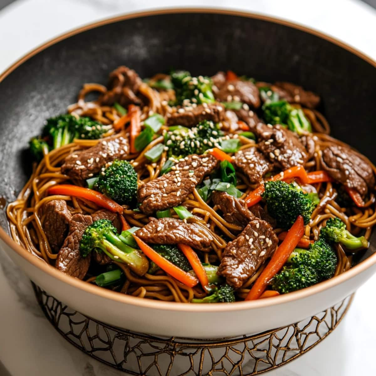 Savory homemade beef and broccoli lo mein with carrots in a bowl.