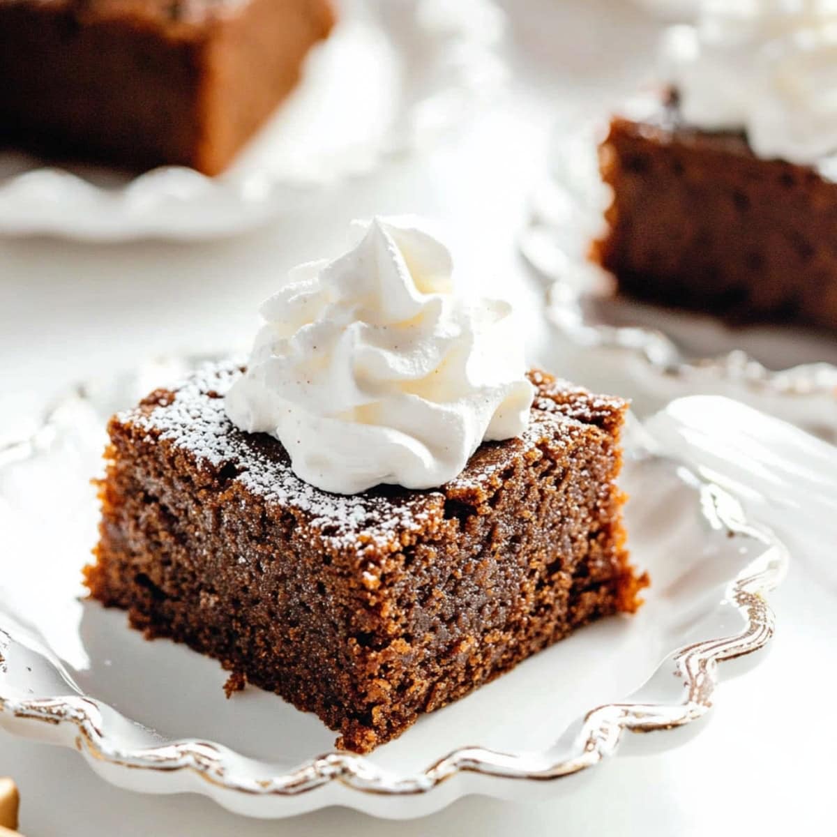 Gingerbread cake with rich molasses and topped with a dollop of whipped cream.