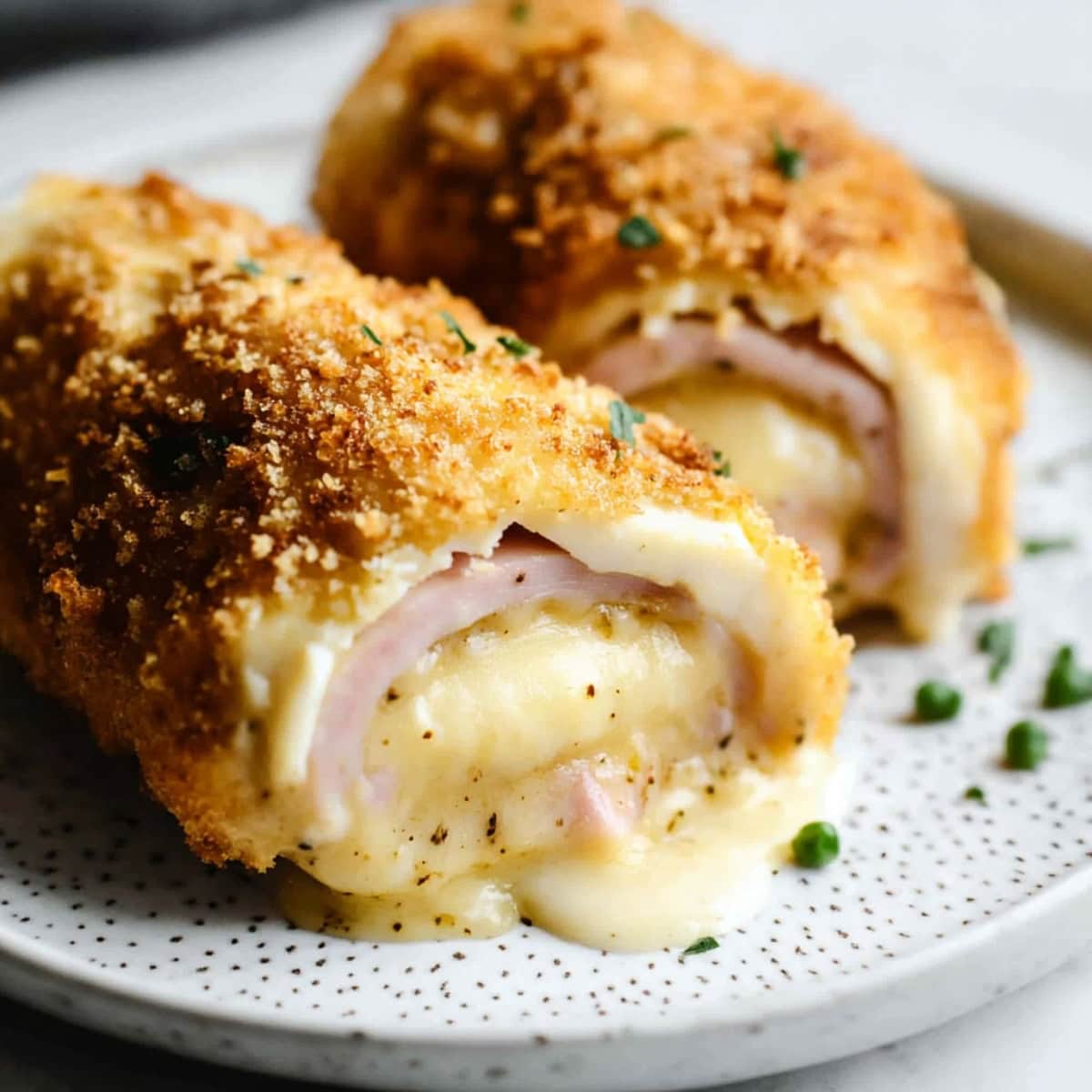 A plate of chicken cordon bleu with ham and cheese.