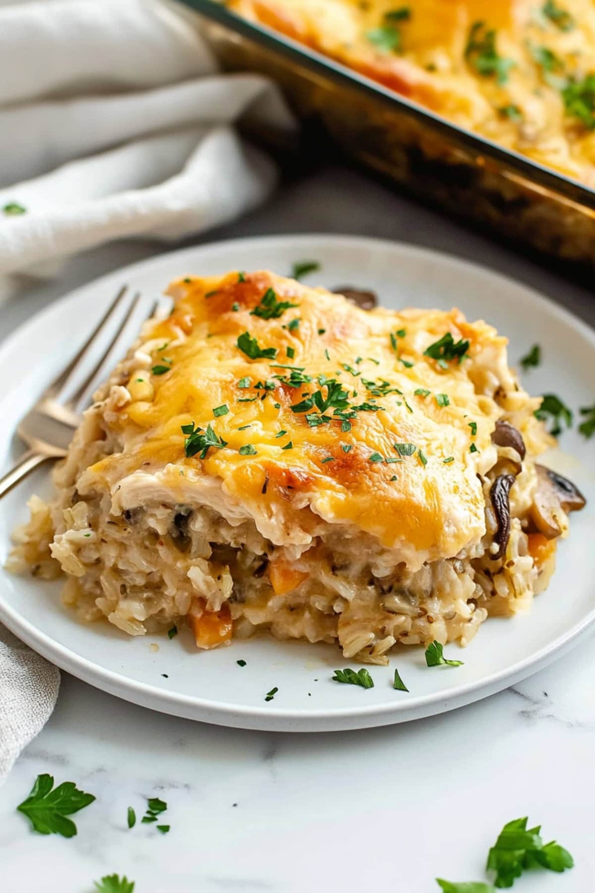 Cheesy homemade chicken wild rice casserole with carrots and mushrooms.