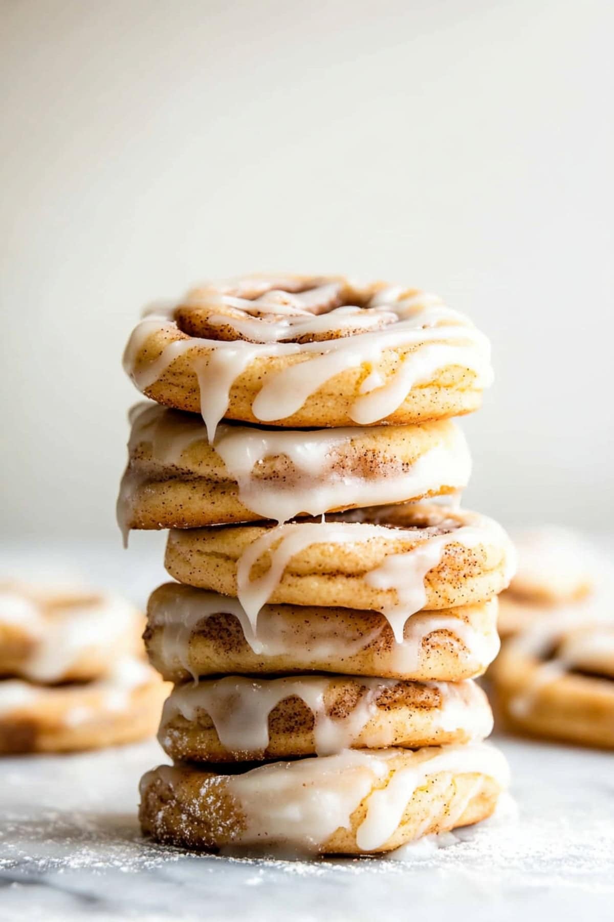 A stack of cinnamon roll cookies with glaze, side view