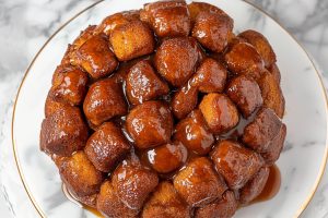 Crockpot monkey bread with sugar glaze served in a white plate