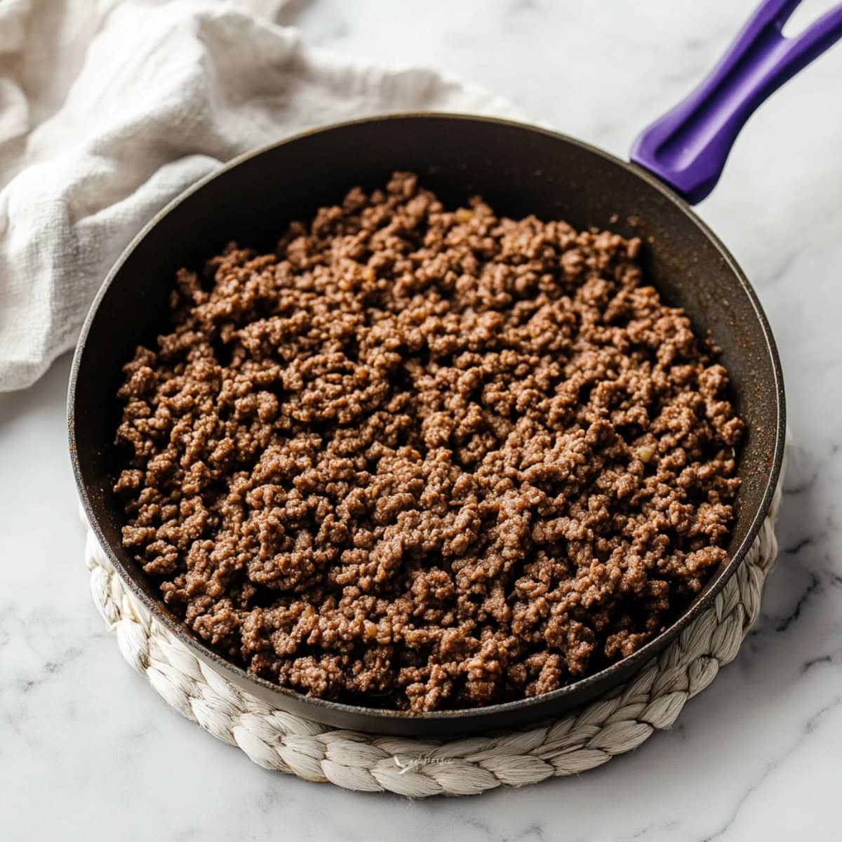 Cooked ground beef with taco spices in a skillet