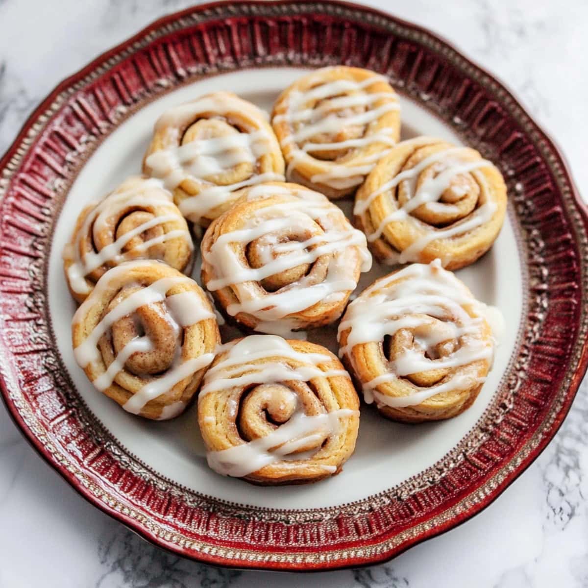 Soft and chewy homemade cinnamon roll cookies with glaze on a plate.