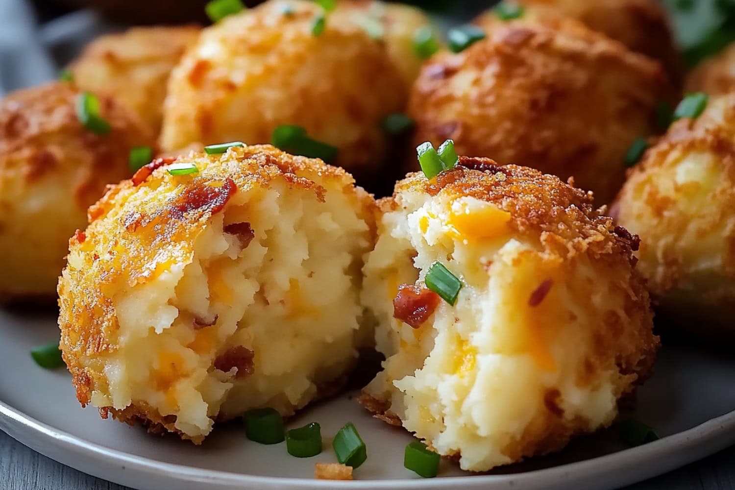 Loaded mashed potato bites with creamy inside served in a dark colored plate.